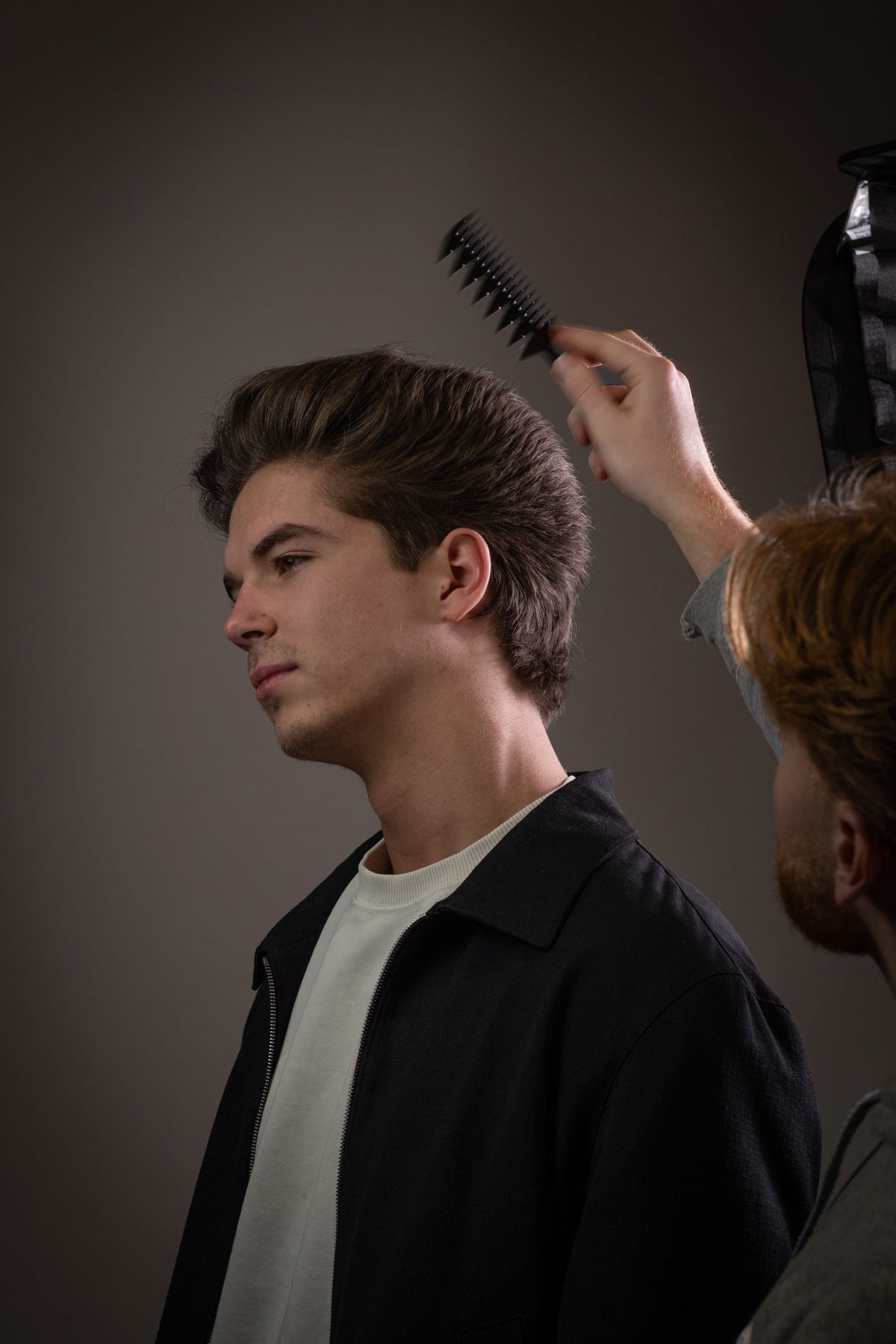 Het haar wordt met een föhnborstel opgeborsteld; studio-opname.